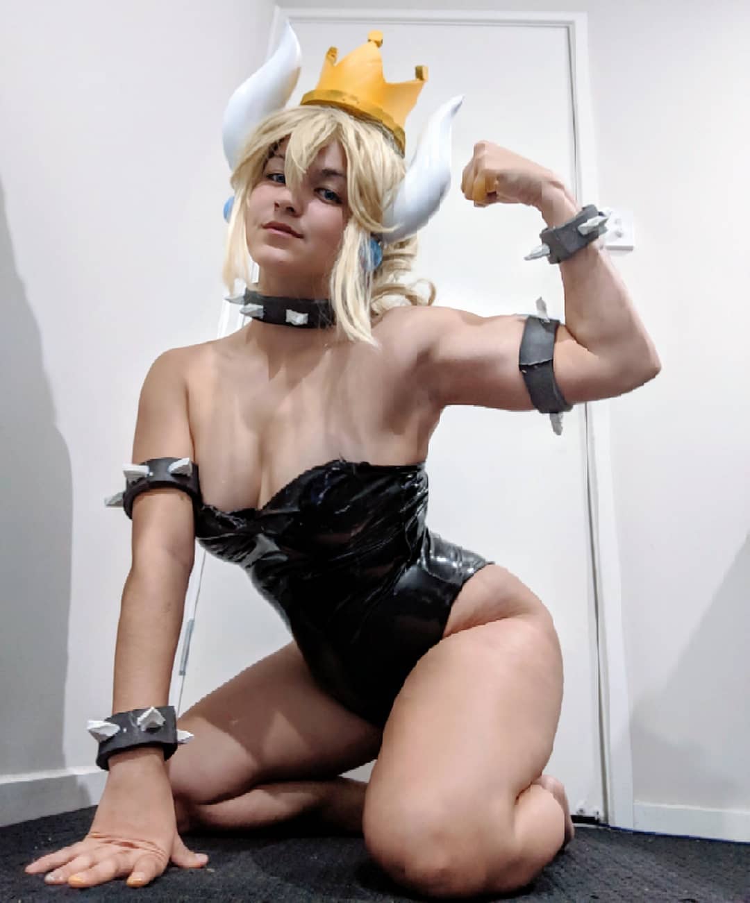 筋肉質な白人コスプレイヤーが力こぶをアピールしながらクッパ姫のコスプレ